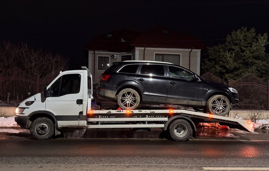 Audi Q7 tractat noaptea, iarna, cu girofarurile aprinse