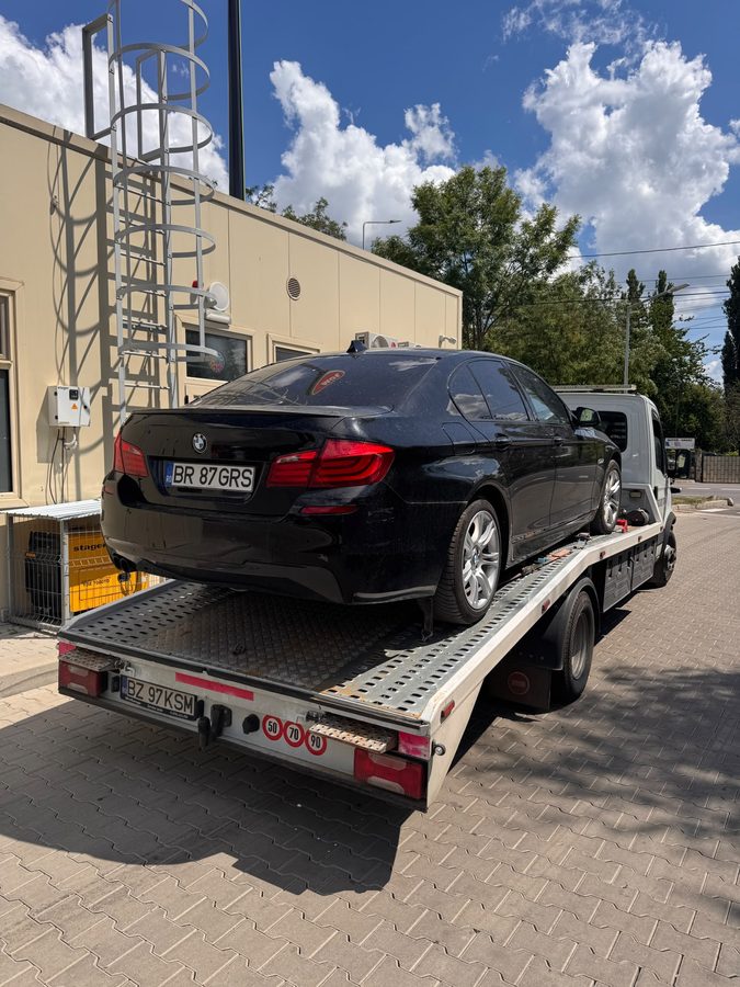 BMW Seria 5 încărcat pe platformă la un service auto